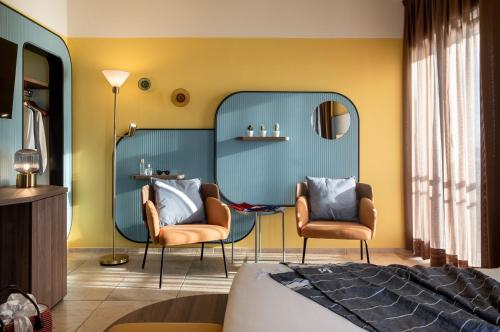 a bedroom with two chairs and a mirror at Hotel Jolly Roger in Pietra Ligure