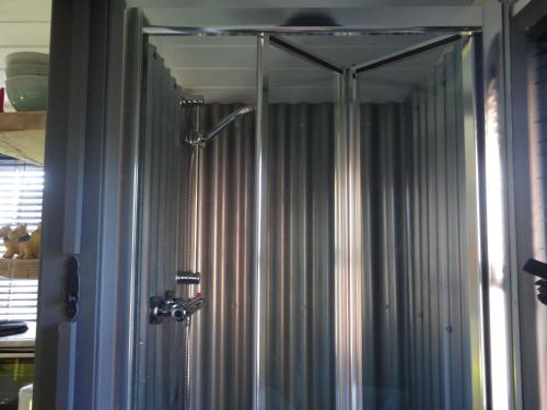 a shower in a bathroom with a shower curtain at Shepherds Hut, Hannahs Retreat, Bowness-on-Solway in Bowness-on-Solway