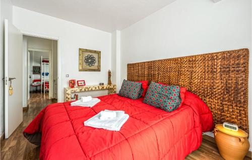 Un dormitorio con una cama roja con toallas. en Amazing Home In Aznalczar With Wifi en Aznalcázar