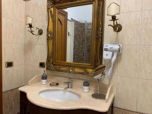 bagno con lavandino e specchio di Anna Rooms ad Aprilia