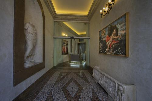 a hallway with paintings on the walls and a painting on the wall at Antica Dimora Delle Cinque Lune in Rome