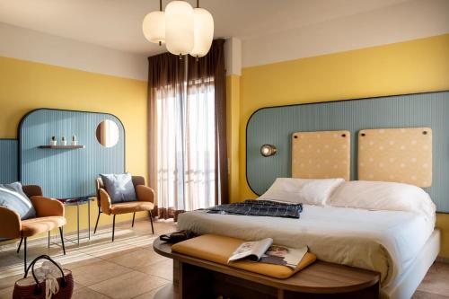- une chambre avec un grand lit et deux chaises dans l'établissement Hotel Jolly Roger, à Pietra Ligure