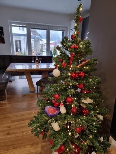 a christmas tree with ornaments on it in a living room at Golf & Ski Appartements Mittersill Trausmuth Monika inkl Sommercard - Golfplatz 500 m entfernt, inkl Waschmaschine, Trockner in Mittersill