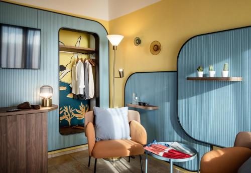 a dressing room with a chair and a table at Hotel Jolly Roger in Pietra Ligure