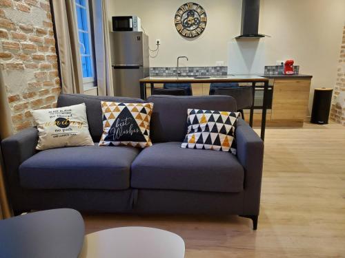 - un canapé bleu avec des oreillers dans la cuisine dans l'établissement Superbe T2 lumineux en centre-ville - parking, à Albi