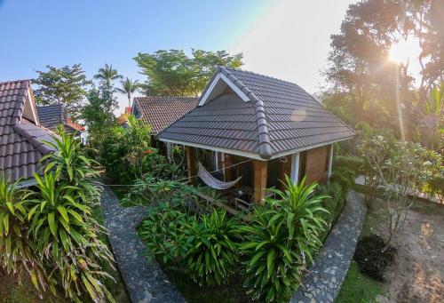 a house with a roof on top of a garden at Pen's Bungalow Koh Phangan in Thong Nai Pan Yai