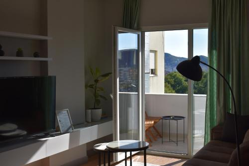 地拉那的住宿－TAM Serviced Apartment Shallvaret Central District，客厅设有大窗户和电视。