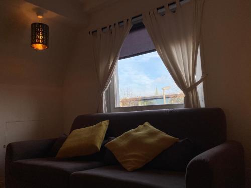 a couch with two pillows sitting in front of a window at Wohnung in Lüneburg in Lüneburg