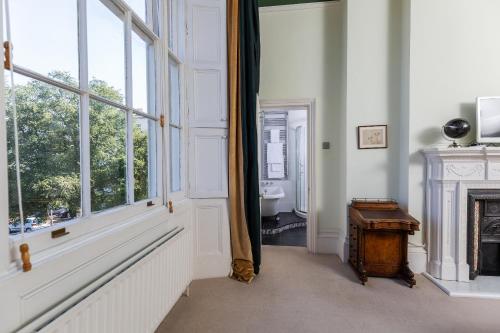 a room with a fireplace and a window and a table at 21 Montpellier House - By Luxury Apartments in Cheltenham