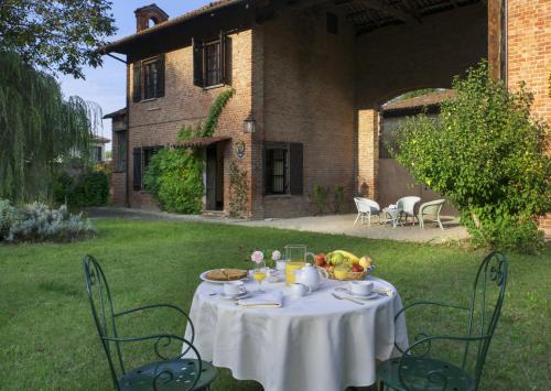 a table with a white table cloth on it in a yard at Marchesi Incisa Winery Lodge in Rocchetta Tanaro