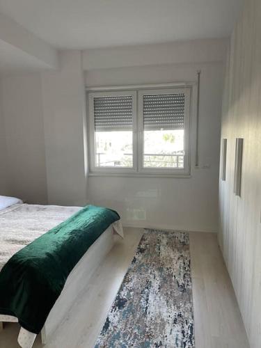 a bedroom with a bed and a window and a rug at Spacious apartment in luxury residence in Çeliku