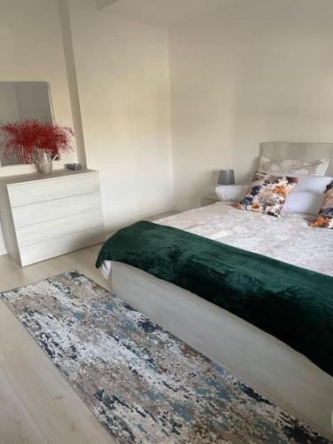 a bedroom with a bed and a rug on the floor at Spacious apartment in luxury residence in Çeliku