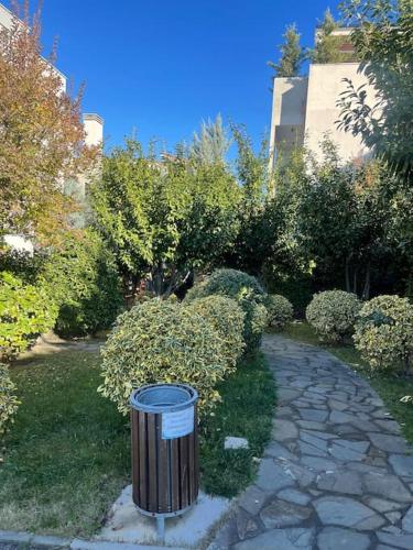 a trash can sitting in the middle of a garden at Spacious apartment in luxury residence in Çeliku