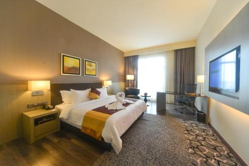 a hotel room with a bed and a television at The Light Hotel Penang in Perai