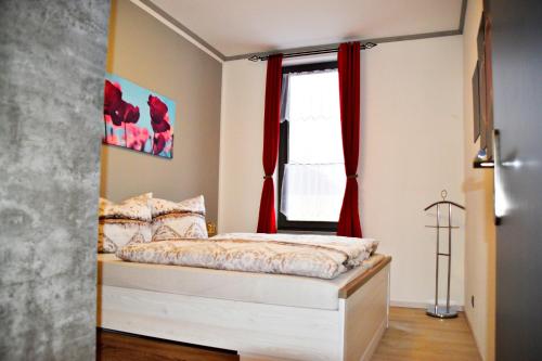 um pequeno quarto com uma cama e uma janela em FeWo Sonja em Sankt Andreasberg