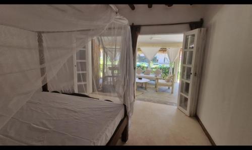 een slaapkamer met een bed en een open deur bij Park Marine Estate II in Malindi