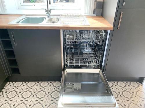an empty dishwasher in a kitchen with a sink at Artist Hideaway Main Street Haworth in Haworth