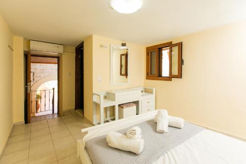 a bedroom with a bed with towels on it at Bezari pool villa in Metochia Fratzeskiana