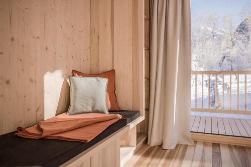 Cette chambre comprend un banc avec un oreiller et une fenêtre. dans l'établissement Pinjola, à Vandans