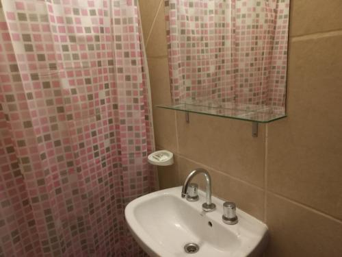 y baño con lavabo y ducha con azulejos rosados. en Las cuatro Hermanas1 en El Calafate