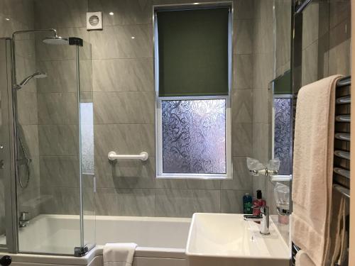 a bathroom with a tub and a sink and a shower at The Bowden Lodge in Southport