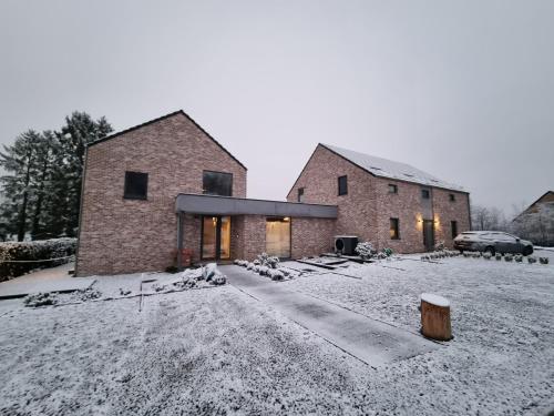 a brick house with snow on the ground at Q-time Barvaux, Durbuy-Adults Only in Durbuy