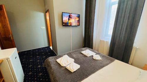 a hotel room with a bed with towels on it at Vila Themis in Călimăneşti