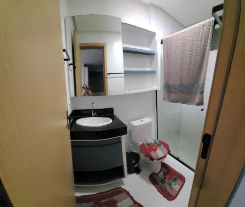 Baño pequeño con lavabo y espejo en Apartamento Condomínio Lençóis Confort, en Barreirinhas