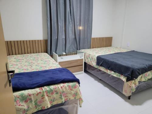 巴雷里尼亞斯的住宿－Apartamento Condomínio Lençóis Confort，一间卧室设有两张床和窗户。