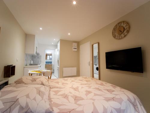 een slaapkamer met een groot bed met een klok aan de muur bij Le Lion - Plain-pied, WIFI, YT Premium - 2RFHomes in Château-Thierry