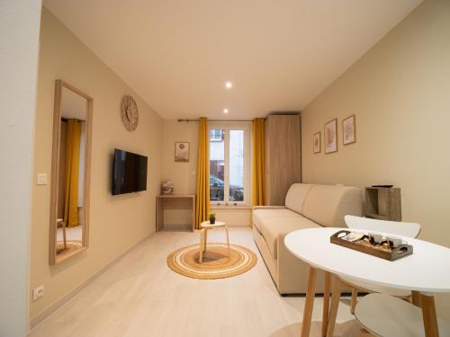 a living room with a couch and a table at Le Lion - Plain-pied, WIFI, YT Premium - 2RFHomes in Château-Thierry