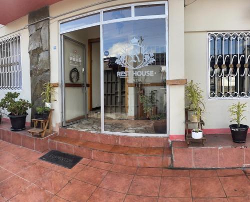 una tienda con una ventana con plantas. en ALOJAMIENTOS HOSTAL REST HOUSE, en Cuenca