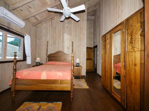 um quarto com uma cama e uma ventoinha de tecto em Hummingbird Beach House em West Bay