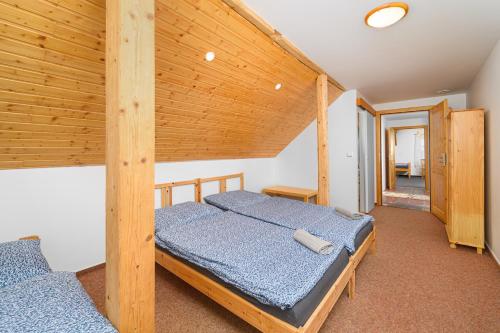 コジェノフにあるHorská chalupa Horní Polubnýの木製の天井が特徴のベッドルーム1室(ベッド2台付)