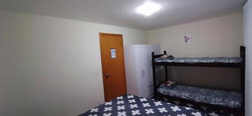 um quarto com 2 beliches e uma porta em Apartamento Temporada em Cabo Frio Arraial do Cabo Cantim do Goiano em Cabo Frio