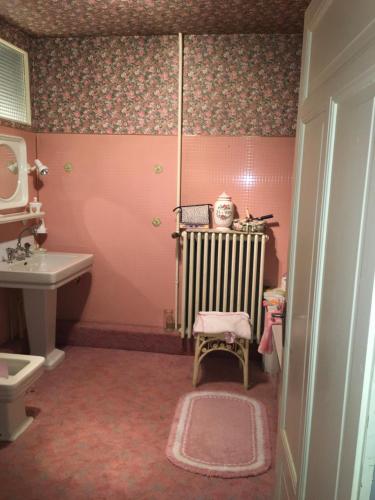 a pink bathroom with a crib and a sink at Les Tilleuls in Morbier