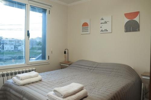 1 dormitorio con 1 cama con toallas en Temporales Ushuaia - Sueños A en Ushuaia