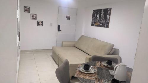 uma sala de estar com um sofá e uma mesa em Flat Mobiliado na Ponta Verde em Maceió