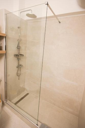 a shower with a glass door in a bathroom at La Petite Fleur Guesthouse in Xylokastron