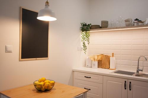 a kitchen with a bowl of fruit on a table at La Petite Fleur Guesthouse in Xylokastron