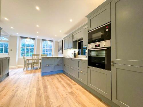 a kitchen with gray cabinets and a wooden floor at Sophisticated 3BR with Garden, quiet New Town Lane in Edinburgh