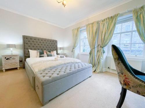 a bedroom with a large bed and two windows at Sophisticated 3BR with Garden, quiet New Town Lane in Edinburgh