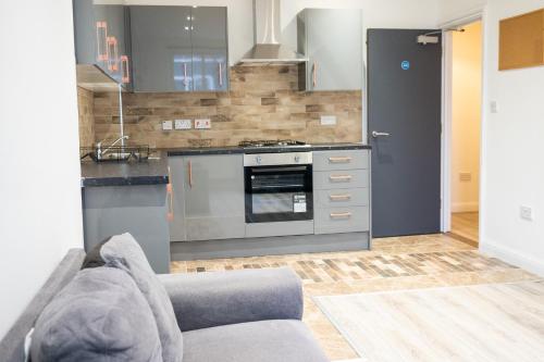 a kitchen with a couch and a stove at 4 Bed, 3 Bath Apartment in City Centre in Portsmouth