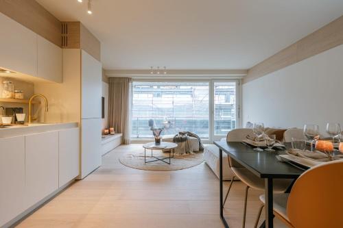 eine Küche und ein Wohnzimmer mit einem Tisch und einem Esszimmer in der Unterkunft Luxurious two bedroom near the sea in Knokke-Heist