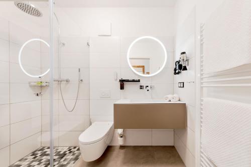 La salle de bains est pourvue de toilettes, d'un lavabo et d'un miroir. dans l'établissement Michels Thalasso Hotel Nordseehaus, à Norderney