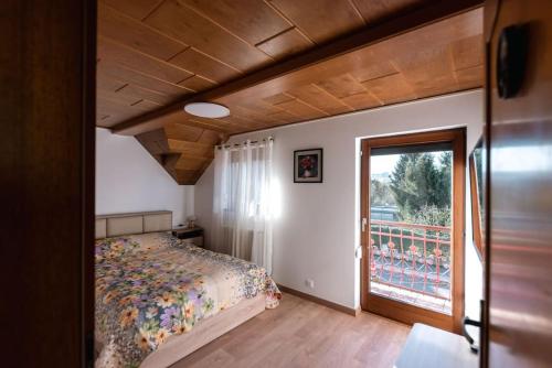 a bedroom with a bed and a large window at L'Escapade Citadine in Bischheim