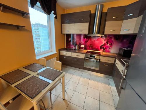 a kitchen with a table and a stove top oven at Cat Garden Elegant Apartments Riga in Rīga