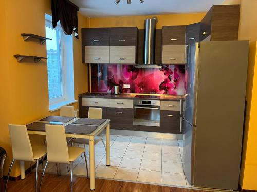 a kitchen with a table and a refrigerator at Cat Garden Elegant Apartments Riga in Rīga