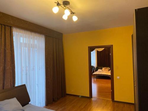 a room with yellow walls and a bedroom with a bed at Cat Garden Elegant Apartments Riga in Rīga