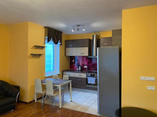 a kitchen with a table and a kitchen with yellow walls at Cat Garden Elegant Apartments Riga in Rīga